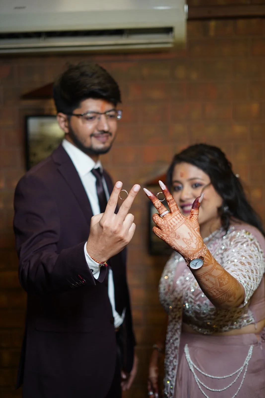 Anmol and Aishwarye holding up their rings